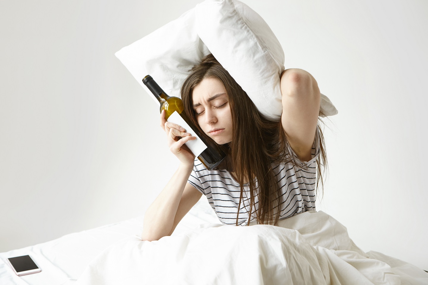 mujer resaca botella vino almohada