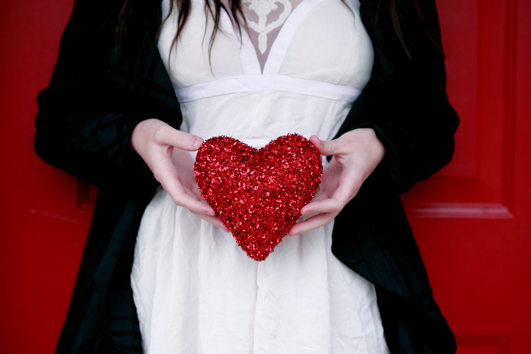 Corazón rojo sostenido por mujer amor vestido blanco