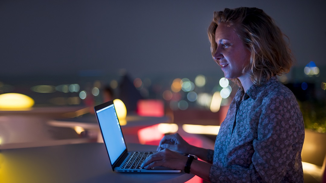 Mujer usando computadora laptop portátil oscuridad