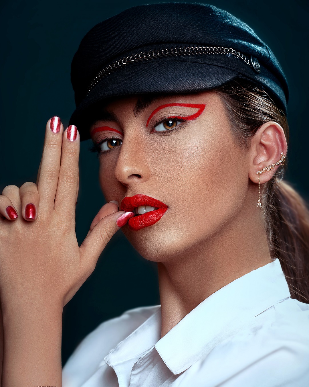 Mujer con labios y uñas pintados de color rojo posando