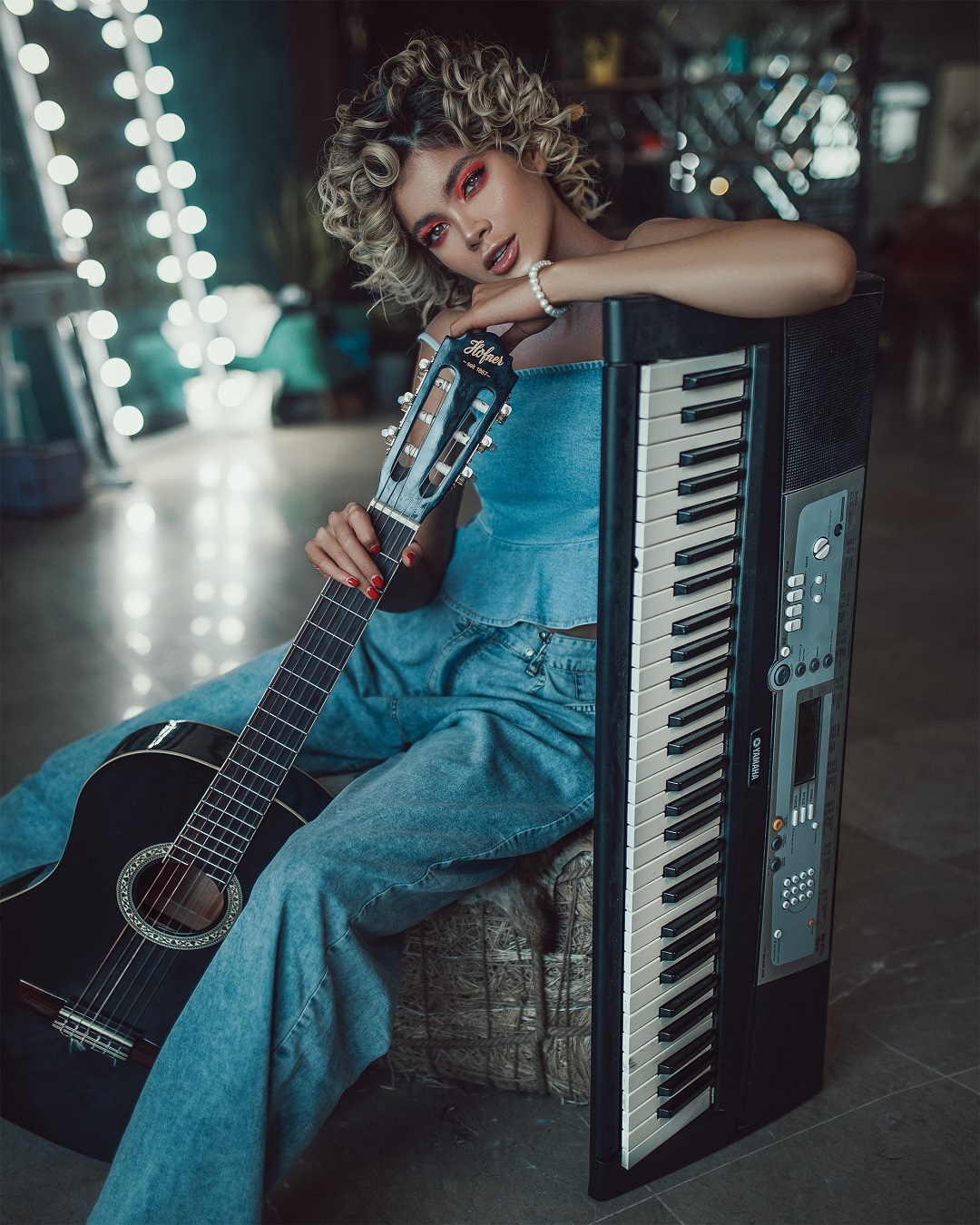 Mujer joven sosteniendo un teclado y guitarra