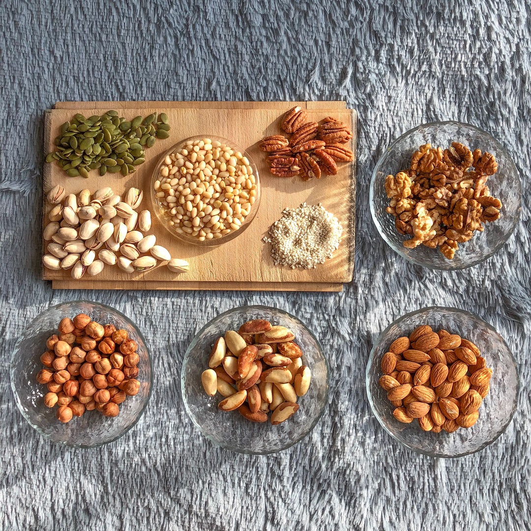variedad de semillas sobre tazones transparentes nueces pistaches garbanzo almendras