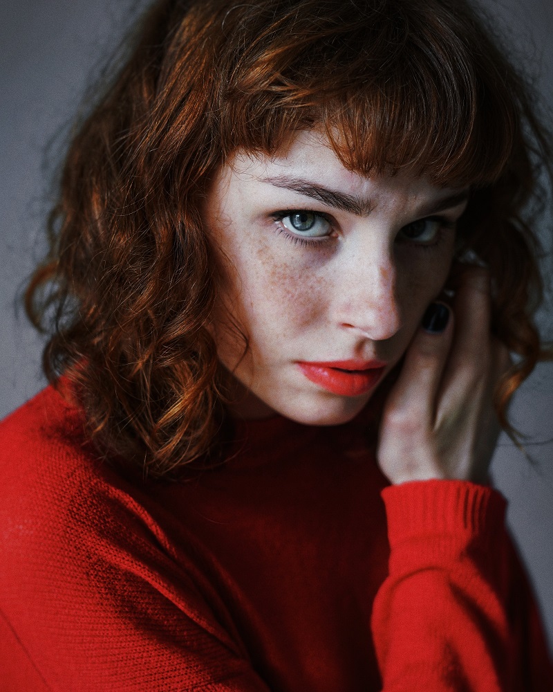 Mujer pelirroja labios y suéter rojos