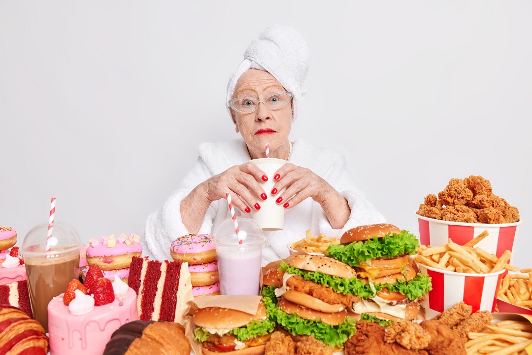 mujer anciana rodeada de comida chatarra