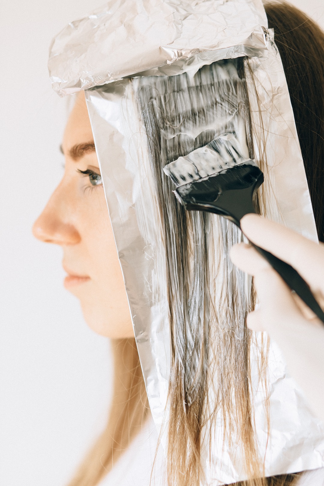 Mujer tiñéndose el cabello tinte