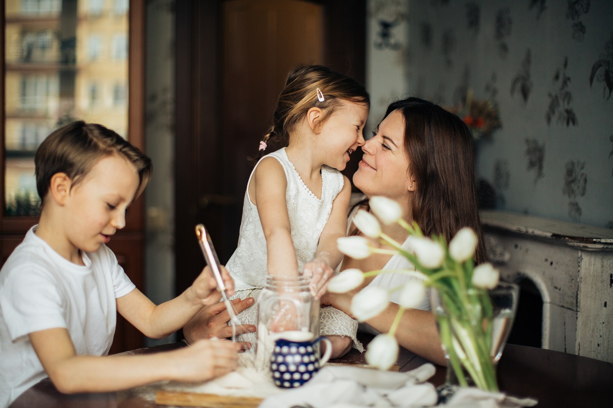 Madre con hija e hijo niños jugando en la mesa