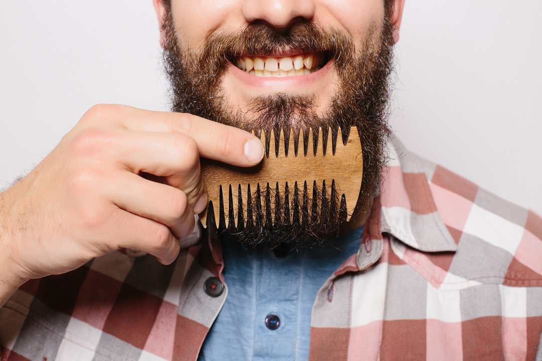 Hombre cepillando su barba peine madera