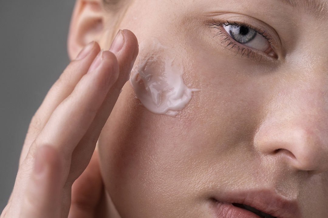 Mujer con crema en la cara skincare suero tratamiento facial