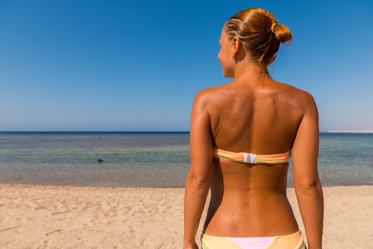 Mujer playa bronceado espalda