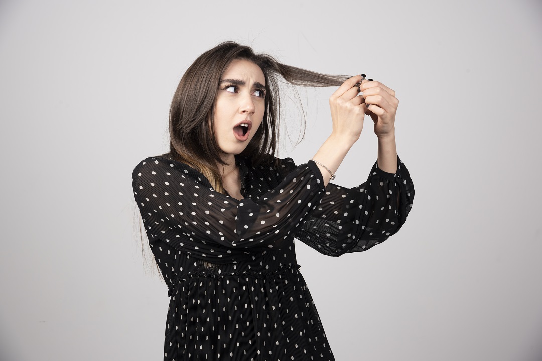 Mujer sosteniendo cabello caída fuerte pelo alopecia