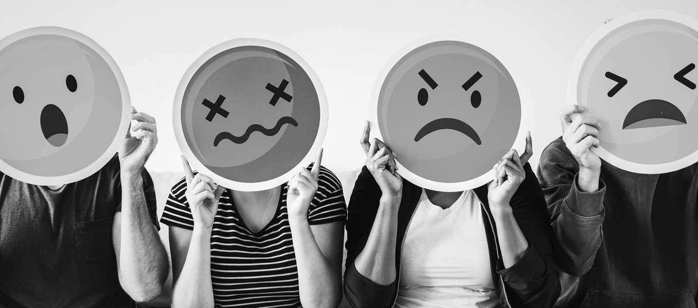 Personas sosteniendo emojis mal humor tristeza confusión ansiedad
