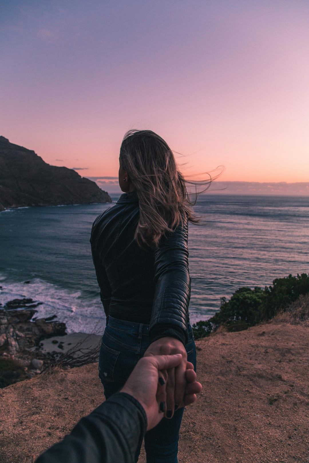 mujer viendo el mar hombre agarrando su mano