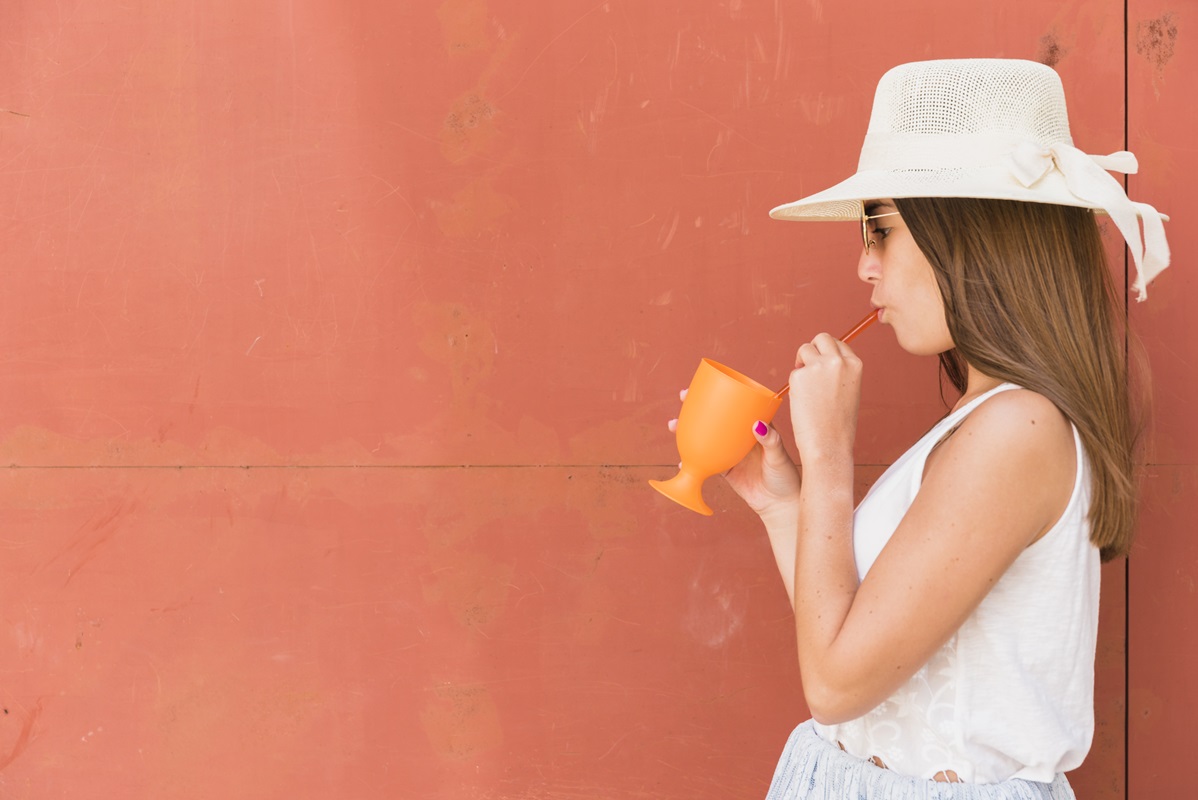 mujer sombrero taza bebiendo pajilla popote