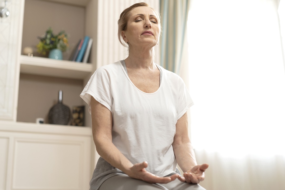 Cheerful mature woman making yoga exercises