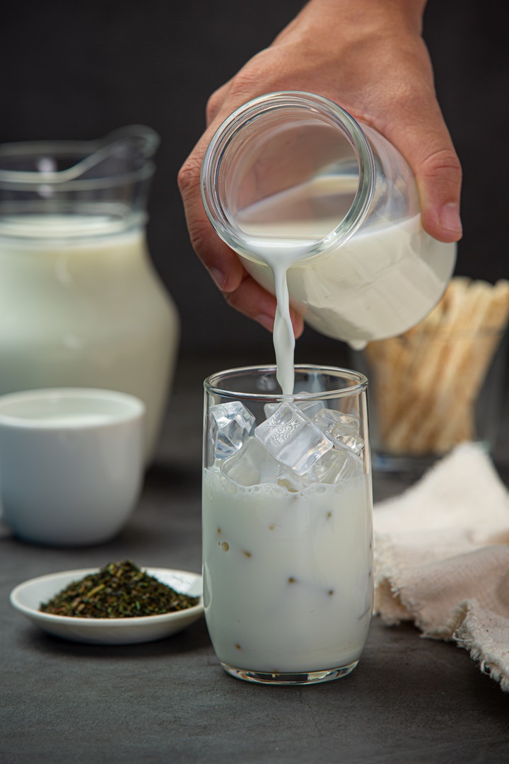 Delicious fresh milk in a glass on a black background